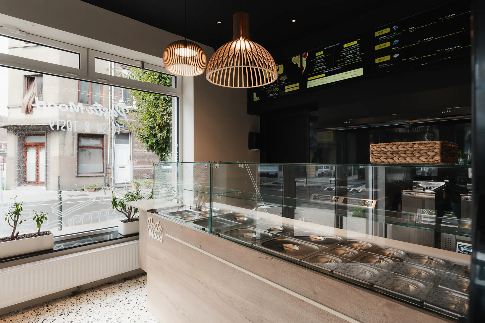 Pendant lights creating focused pools of warm light beneath a dark restaurant ceiling